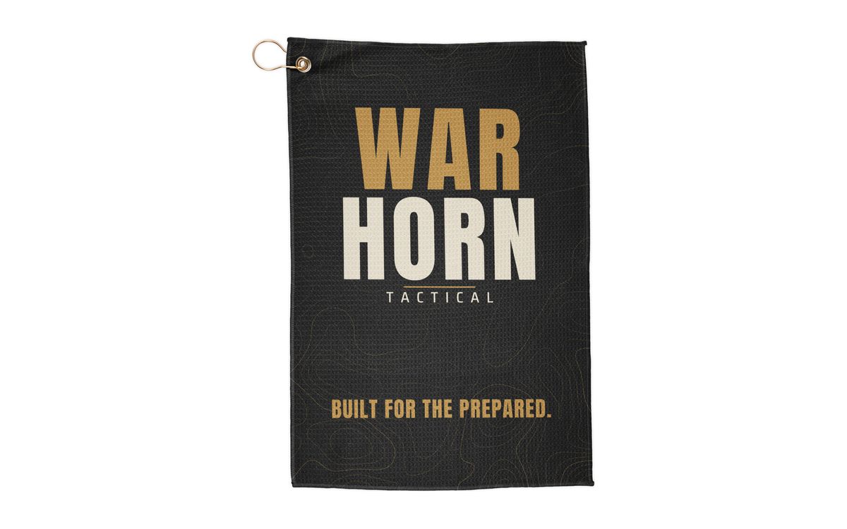 Wordmark Range Towel: black towel with a stacked gold WAR and bone HORN wordmark, TACTICAL, and BUILT FOR THE PREPARED. over faint gold topo lines