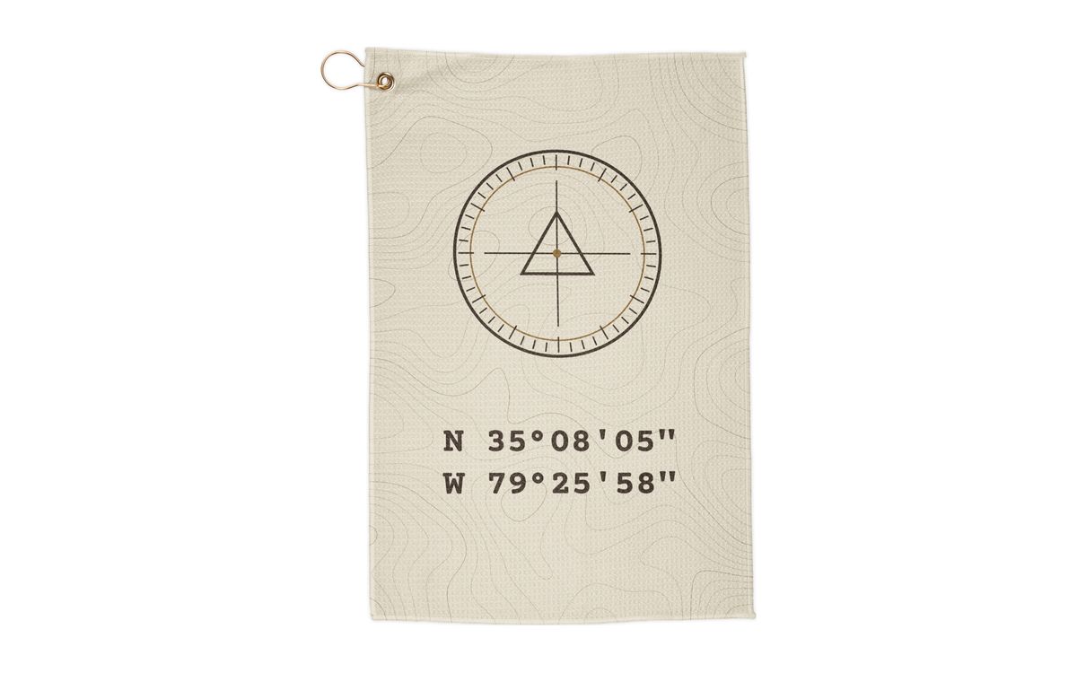 Bone Benchmark Range Towel: bone towel with topo lines, a survey benchmark marker and the coordinates N 35°08′05″ W 79°25′58″